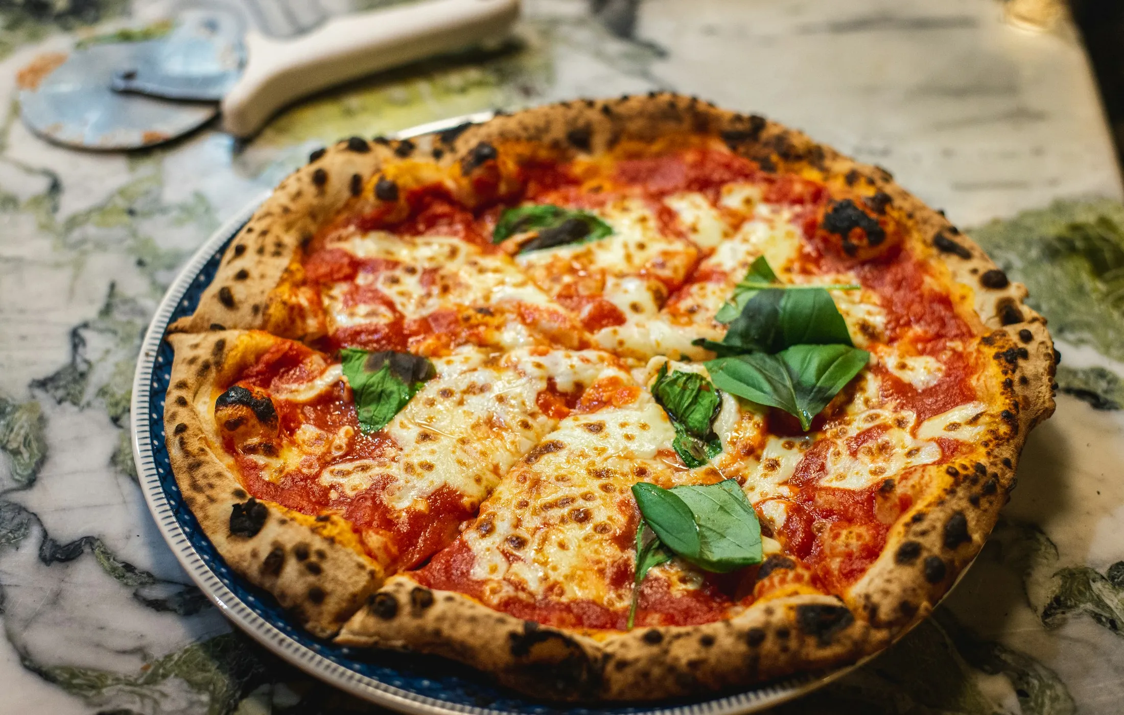 A freshly baked pizza on a wooden board at Goya's Pizza